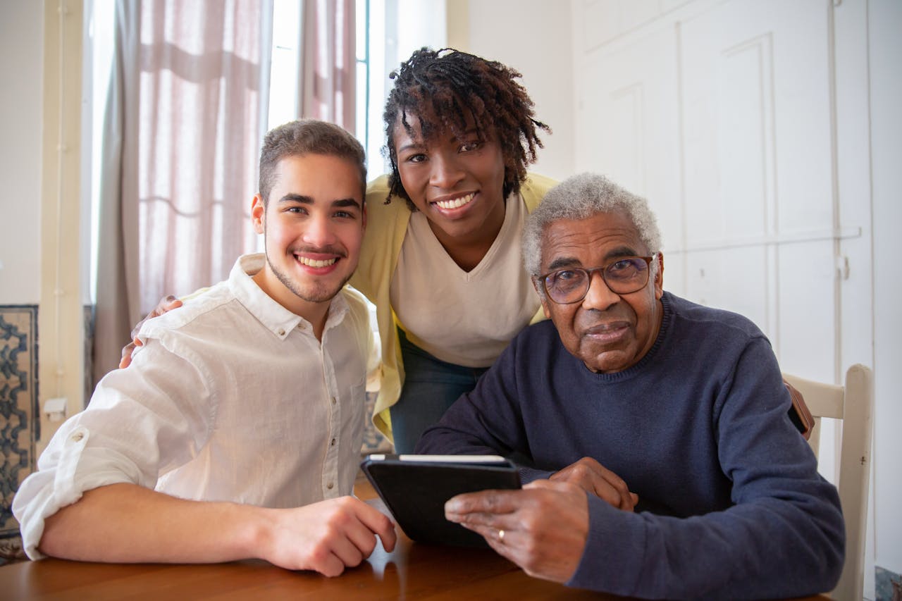 cta-02 Elderly man enjoying technology with diverse caregivers at home.