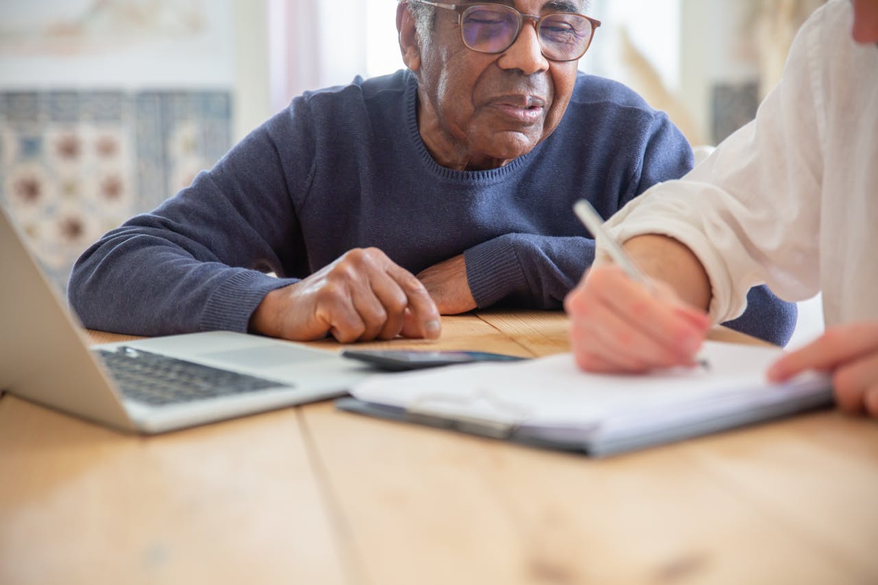 gallery-img-01 Senior African American man receiving assistance with paperwork at home.